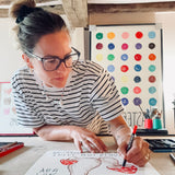 Alma Singer drawing a red toadstool for Earthling's nursery art collection