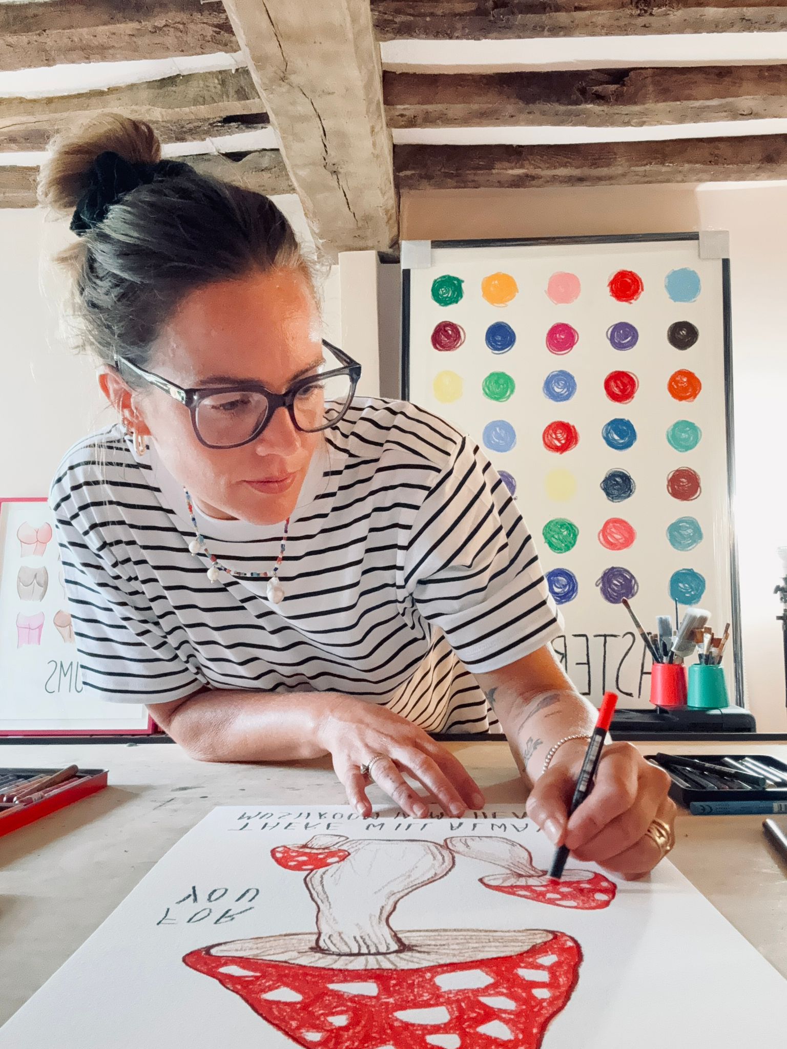 Alma Singer drawing a red toadstool for Earthling's nursery art collection