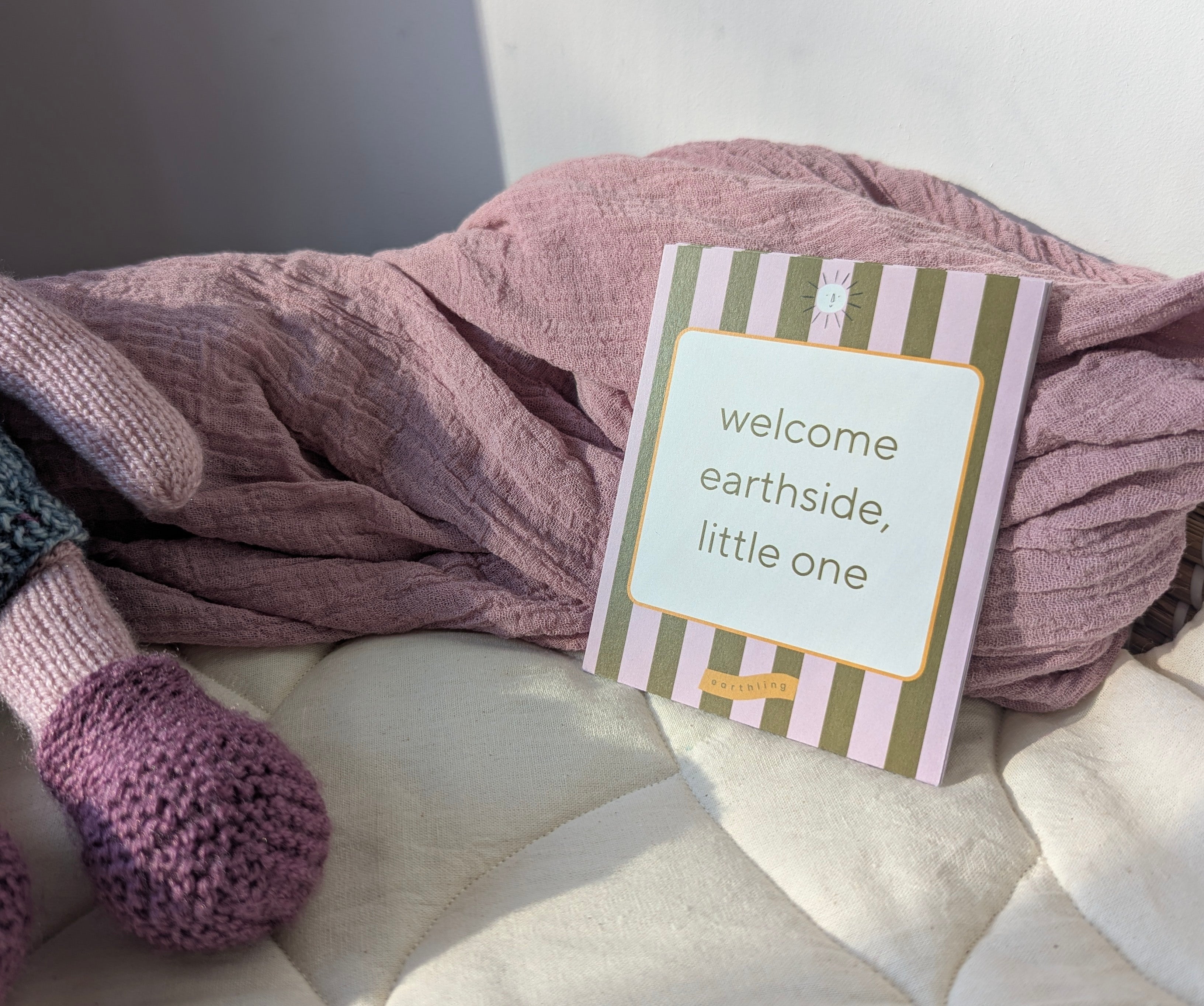 You+Me Milestone cards and affirmation cards in basket with liner and dusky purple linen and knitted doll